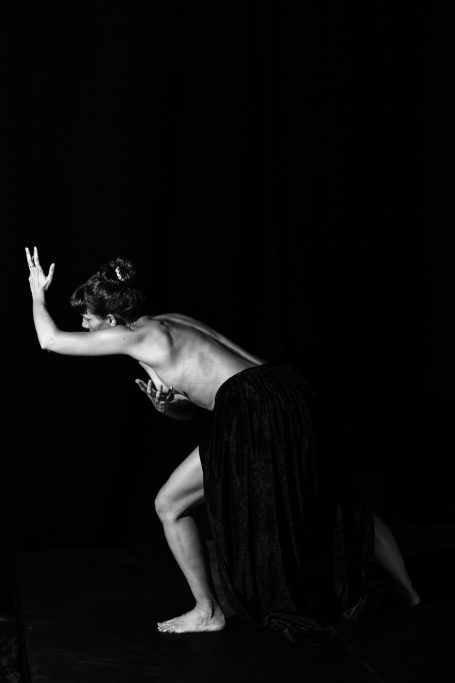 El lamento Mujer en pose dramática, vestida con falda larga, sobre fondo negro.